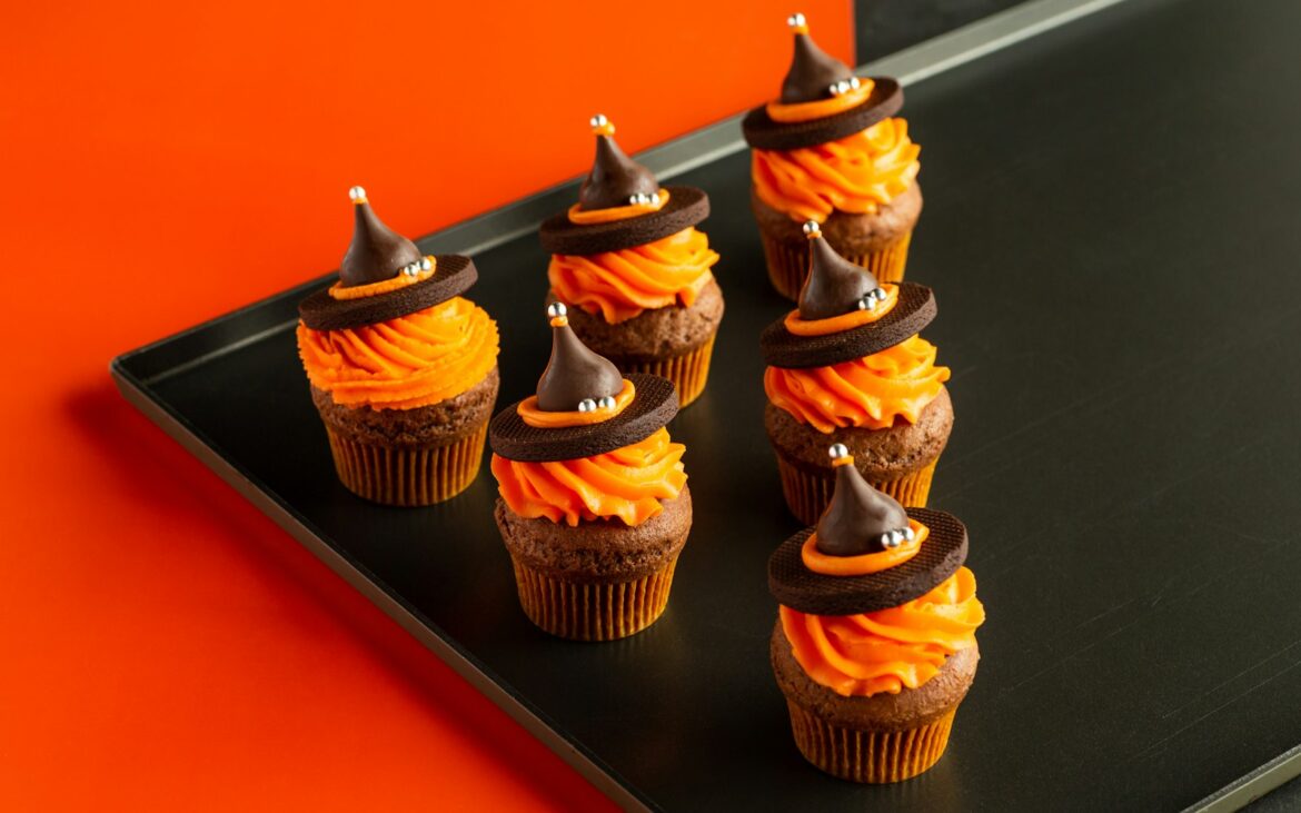 Tray of Halloween cupcakes with orange frosting and chocolate decorations
