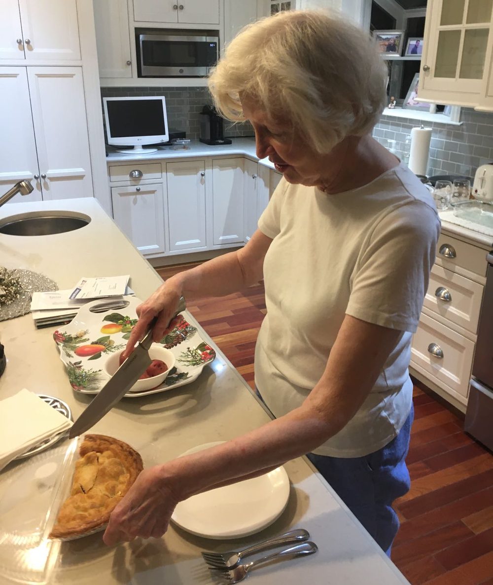 Fluffy slicing a homemade pie on the counter in her kitchen